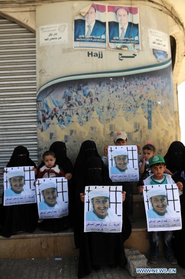 Family members of Yemeni prisoners in Guantanamo display the pictures of them during a rally demanding the release of prisoners held in Guantanamo, in front of the Yemeni President's Palace, in Sanaa, Yemen, Jan. 14, 2013. (Xinhua/Mohammed Mohammed)