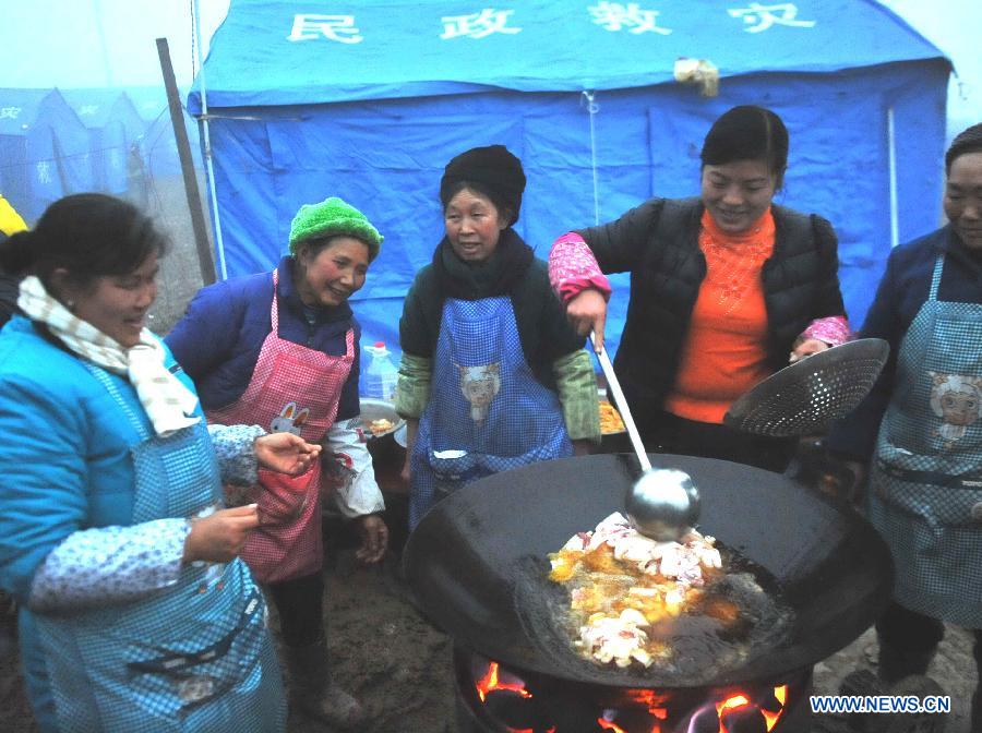 Villagers cook in the makeshift tents near the Gaopo Village in Zhenxiong County of Zhaotong City, southwest China's Yunnan Province, Jan. 14, 2013. Forty-six people died and 2 others injured in a landslide which hit the Zhaojiagou area of Gaopo Village around 8:20 a.m. on Jan. 11. More than 500 villagers have been moved to makeshift tents near the village. (Xinhua/Chen Haining)  