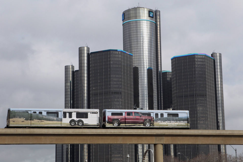 Two cars of the “people mover” public rail are seen covered with an advertisement for the 2014 Chevy Silverado pickup truck as they move past General Motors World Headquarters in Detroit, Michigan, Jan. 11, 2013. (Xinhua/Reuters)