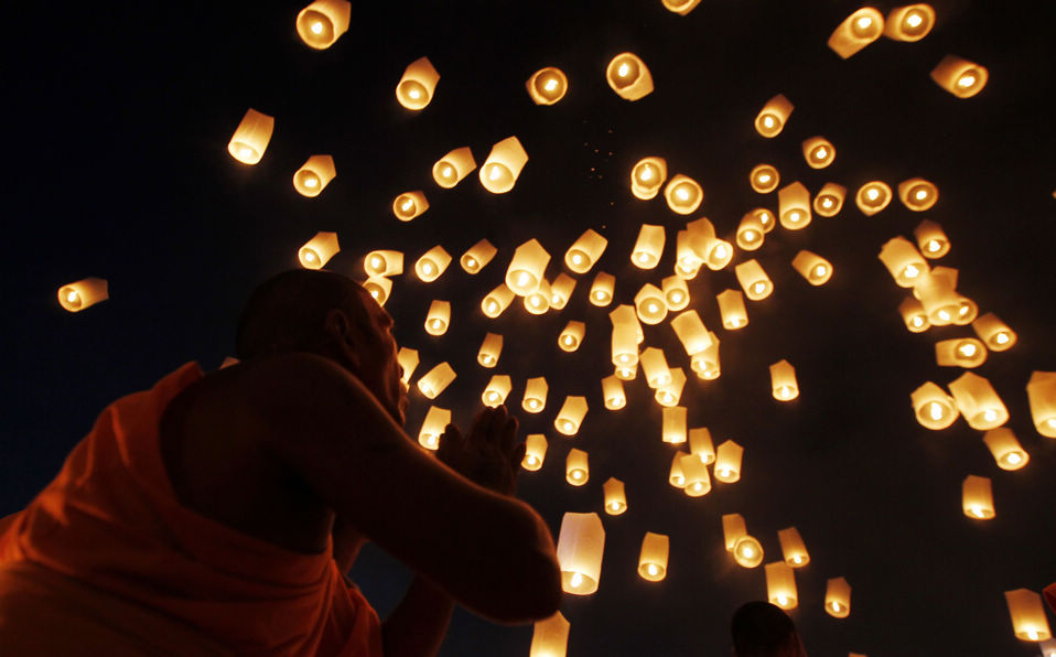 Buddhist monks release paper lanterns into the sky to pay homage to Lord Buddha and bless Thailand as it enters the new year. (Xinhua/Reuters)