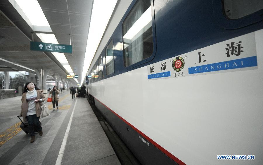 A passenger walks past the Z124/Z122 express sleeper train from Chengdu to Shanghai in Chengdu, capital of southwest China's Sichuan Province, Jan. 15, 2013. The Z124/Z122 train from Chengdu to Shanghai, which started operation on Tuesday, is the first express sleeper train in southwest China and the fastest among all trains running between Chengdu and Shanghai. (Xinhua/Xue Yubin)