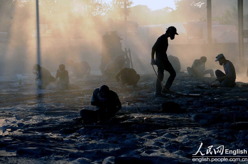 Workers wearing dust-proof masks work in a stone caving factory in Quanzhou, Fujian on Oct. 25, 2012. (Photo/People's Daily Online)