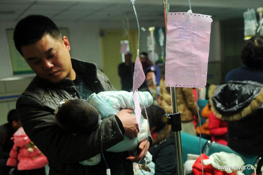 A father holds his child who is receiving an intravenous infusion for respiratory diseases in a hospital in Shijiazhuang City, capital of north China's Hebei Province, Jan. 15, 2013. The number of children suffering from respiratory diseases increased enormously due to prolonged smoggy weather in the past few days. (Xinhua/Zhu Xudong) 