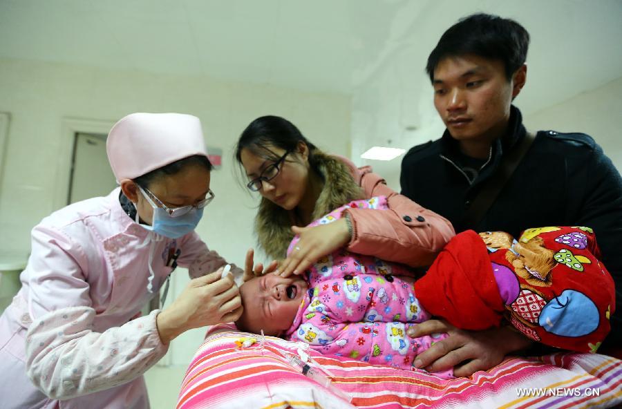 A nurse tries to give a child an acupuncture treatment in a hospital in Huaibei, east China's Anhui Province, Jan. 14, 2013. Continuous foggy condition in many Chinese cities these days has caused more children to get sick. (Xinhua/Wan Shanchao) 