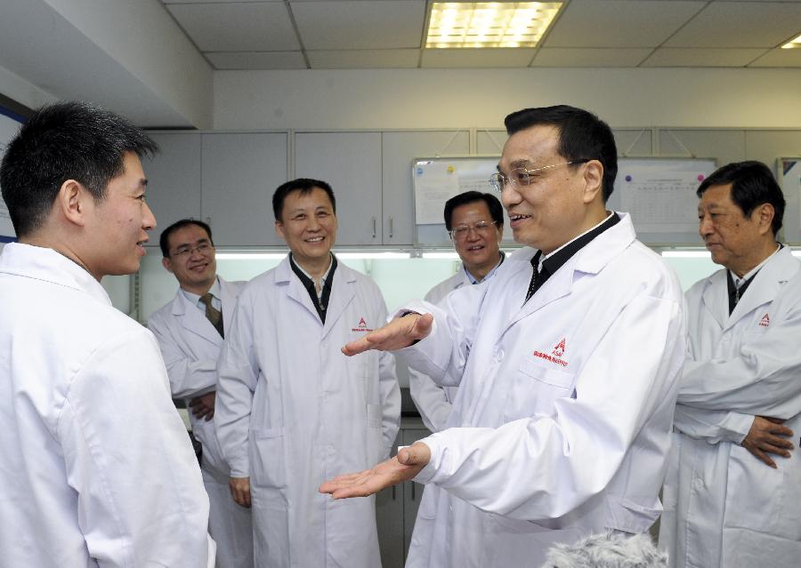 Chinese Vice Premier Li Keqiang (2nd R), who is also a member of the Standing Committee of the Political Bureau of the Communist Party of China (CPC) Central Committee, talks with a staff member at the food safety laboratory of the Academy of State Administration of Grain (ASAG) in Beijing, capital of China, Jan. 15, 2013. Li made an inspection tour in ASAG and presided over a symposium after visiting the academy's grain storage laboratory and food safety laboratory on Tuesday. (Xinhua/Zhang Duo)