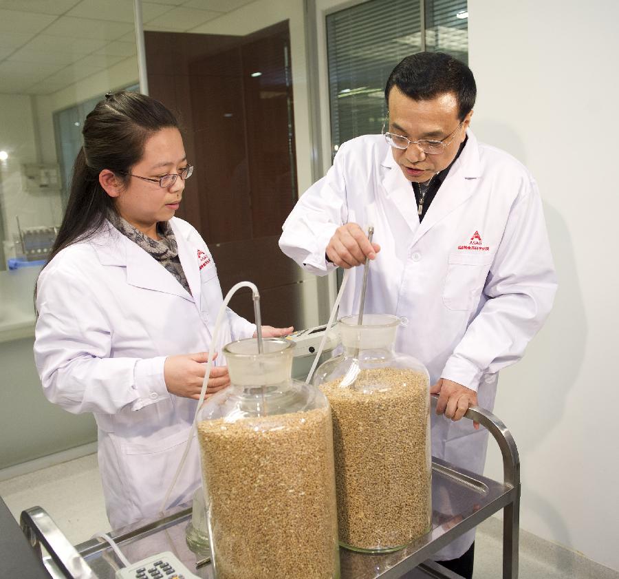 Chinese Vice Premier Li Keqiang (R), who is also a member of the Standing Committee of the Political Bureau of the Communist Party of China (CPC) Central Committee, tries to operate a test device at the grain storage laboratory of the Academy of State Administration of Grain (ASAG) in Beijing, capital of China, Jan. 15, 2013. Li made an inspection tour in ASAG and presided over a symposium after visiting the academy's grain storage laboratory and food safety laboratory on Tuesday. (Xinhua/Huang Jingwen) 