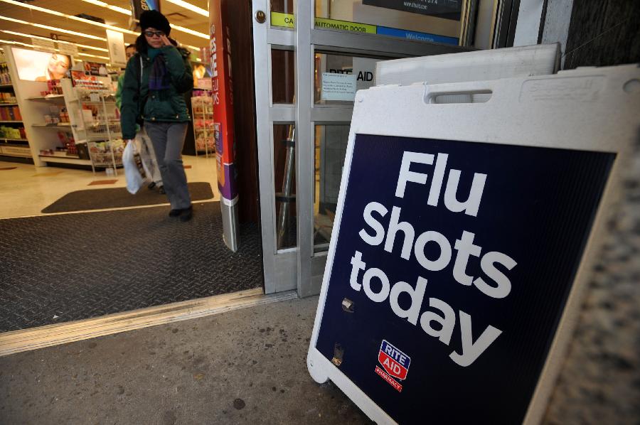A sign advertising the availability of flu shots is put outside a CVS pharmacy store in New York, the United States, Jan. 15, 2013. As of Sunday, more than 20,000 cases of influenza have been reported in New York State for this season, far more than the 4, 404 cases that were reported in the last season. (Xinhua/Wang Lei) 