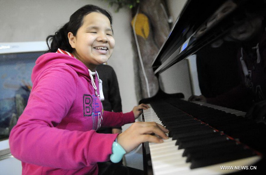 A blind orphan plays the piano in a classroom in Ningxia Children Welfare Center in Yinchuan, capital of northwest China's Ningxia Hui Autonomous Region, Jan. 15, 2013. The welfare center recently moved to a new home, providing a more comfortable living environment to more than 300 orphans. (Xinhua/Li Ran)  