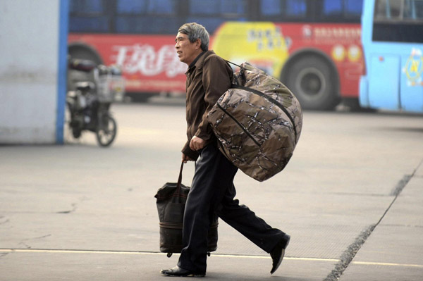 A passenger with big bags of luggage at Yangzhou West Bus station in East China’s Zhejiang province, on Jan 15, 2013. Hangzhou railway station is expected to transport around 34 million people during the approaching Spring Festival travel rush, which is still more than 10 days away.(Photo/Xinhua)