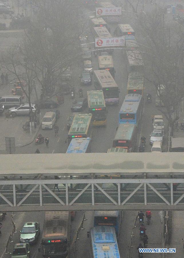 Vehicles line up in the street amid the heavy fog in Zhengzhou, capital of central China's Henan Province, Jan. 16, 2013. Affected by a cold front, the haze which has lingered in most parts of Henan for the past two weeks will begin to disperse on Jan. 17, according to the meteorological authority. (Xinhua/Wang Song)
