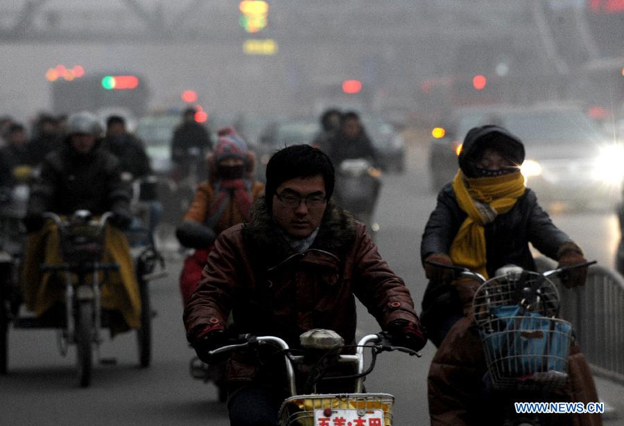 Citizens ride motorcycles amid heavy fog in Zhengzhou City, capital of central China's Henan Province, Jan. 16, 2013. The fog and smog has lingered in Zhengzhou for a few days, affecting local traffic and residents' daily life. (Xinhua/Zhu Xiang)