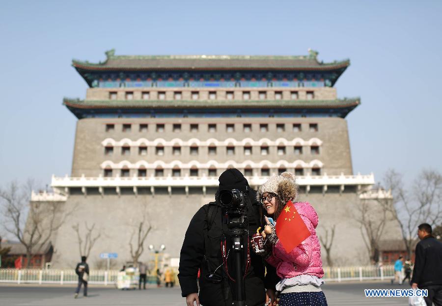 Tourists visit the Qianmen Street in Beijing, capital of China, Jan. 16, 2013. Beijingers on Wednesday saw their first sunshine in seven days, with a cold front dispersing the lingering smog in the city. (Xinhua/Li Fangyu)