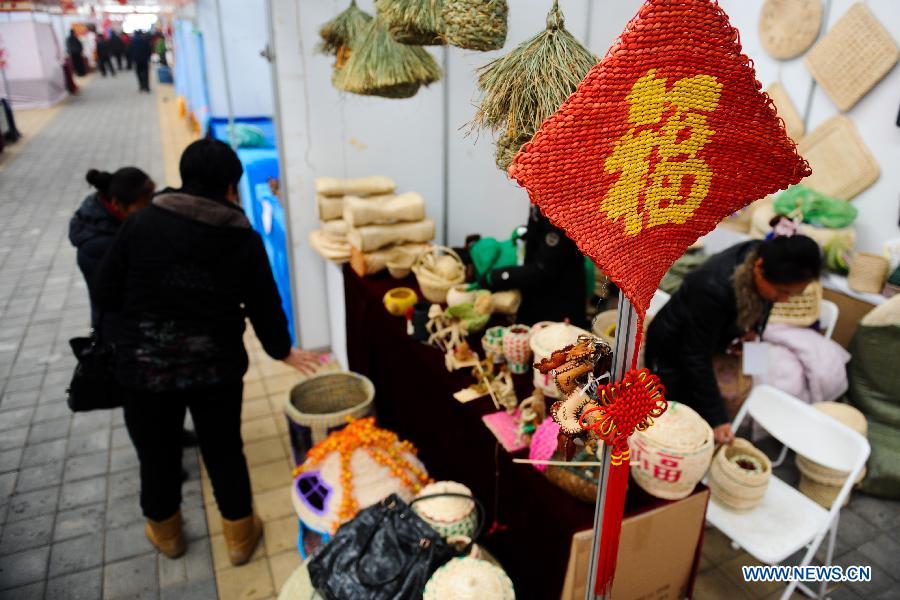 Visitors select handicraft artworks during the 4th Jilin Agricultural Expo for Winter in Changchun, capital of northeast China's Jilin Province, Jan. 16, 2013. Many people came to purchase goods for the coming Spring Festival. (Xinhua/Xu Chang)