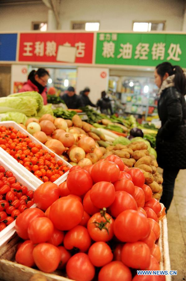 A local resident selects vegetables at a market on Tabei Road in Shijiazhuang, capital of north China's Hebei Province, Jan. 16, 2013. According to the Ministry of Commerce, the price of agricultural products in 36 large-and-medium-sized cities across the nation continued to rise from Jan. 7, 2013 to Jan. 13, 2013, a continuous rising in 11 consecutive weeks. (Xinhua/Zhu Xudong)