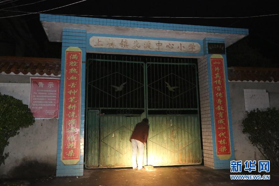 The photo taken on Jan. 15 shows a village trying to peek into the primary school yard through the gates, Xinhua county, Hunan province. On the afternoon of Jan. 13, an unidentified man broken into a primary school, stabbed a student and then ran away. After received the report, Yang Jianyi, the school’s headmaster chased after the attacker and was killed by severe wounds on the head during the fight. At present, the police investigation is underway. (Xinhua/Guo Guoquan)