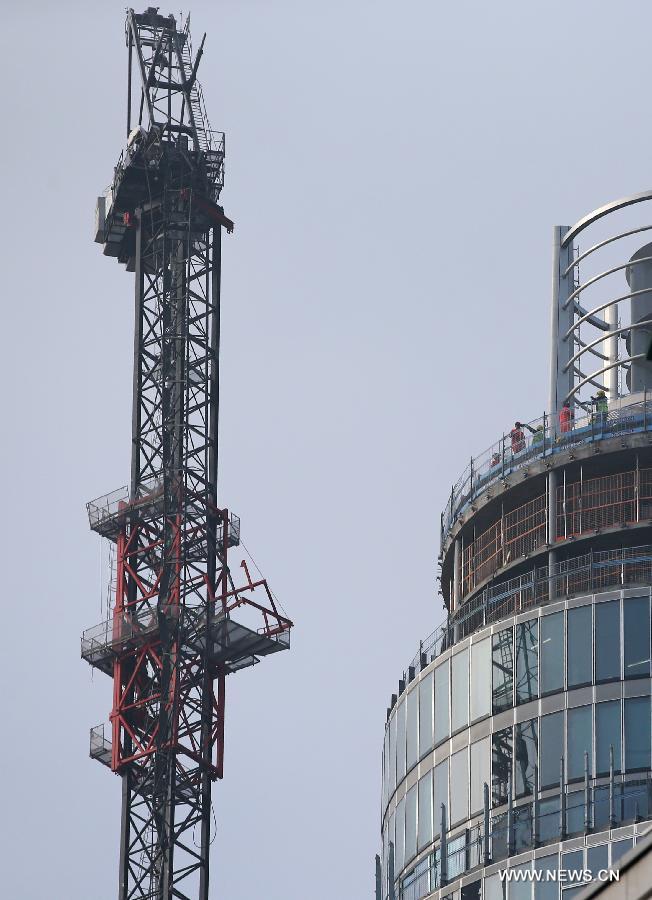 Rescuers inspect the damaged crane at the scene of a helicopter crash in central London, Britain, Jan. 16, 2013. Two people were killed and another two were injured after a helicopter crashed into a construction crane near Wandsworth Road, south of River Thames in central London earlier on Wednesday. (Xinhua/Yin Gang)