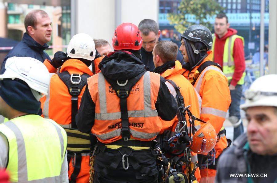 Rescue workers are seen at the scene of a helicopter crash in central London, Britain, Jan. 16, 2013. Two people were killed and another two were injured after a helicopter crashed into a construction crane near Wandsworth Road, south of River Thames in central London earlier on Wednesday. (Xinhua/Yin Gang)