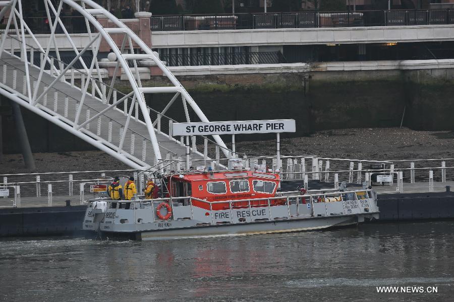 Fire fighters arrive at the dock near the scene of a helicopter crash in central London, Britain, Jan. 16, 2013. Two people were killed and another two were injured after a helicopter crashed into a construction crane near Wandsworth Road, south of River Thames in central London earlier on Wednesday. (Xinhua/Yin Gang)