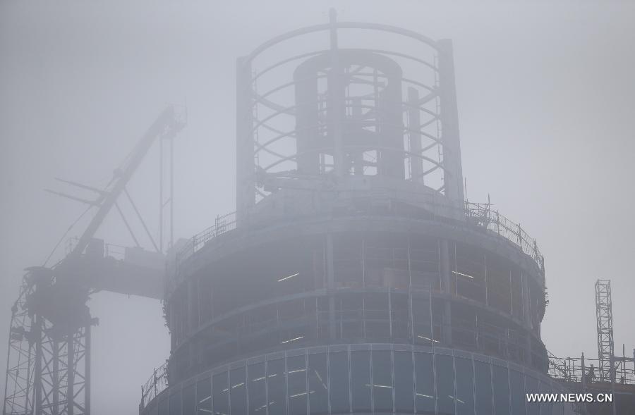 Photo taken on Jan. 16, 2013 shows the damaged crane and the apartment block in the fog at the construction site of the apartment block in central London, Britain. Two people were killed and another two were injured after a helicopter crashed into a construction crane near Wandsworth Road, south of River Thames in central London earlier on Wednesday. (Xinhua/Yin Gang)