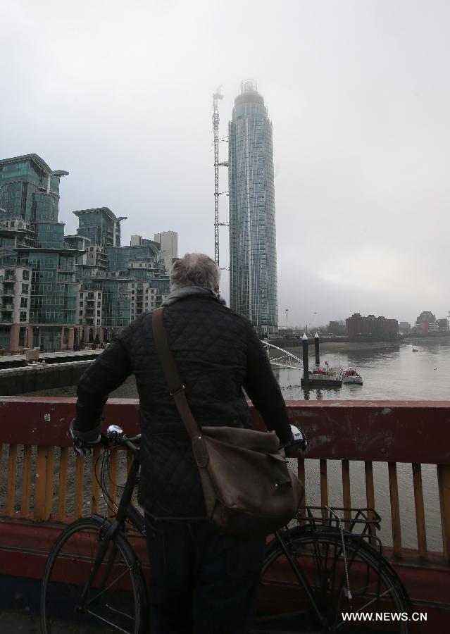 A man looks at the damaged crane at the construction site of the apartment block in central London, Britain, Jan. 16, 2013. Two people were killed and another two were injured after a helicopter crashed into a construction crane near Wandsworth Road, south of River Thames in central London earlier on Wednesday. (Xinhua/Yin Gang)
