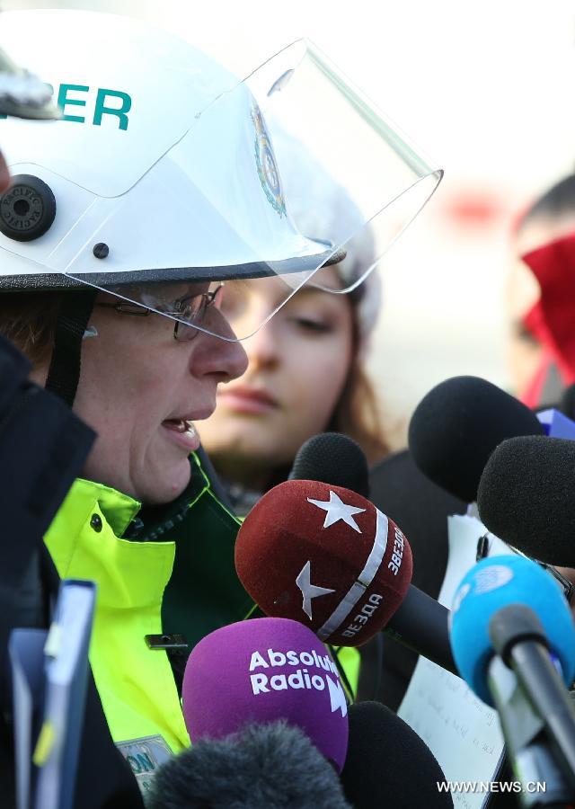 A policewoman answers questions on the helicopter crash incident in central London, Britain, Jan. 16, 2013. Two people were killed and another two were injured after a helicopter crashed into a construction crane near Wandsworth Road, south of River Thames in central London earlier on Wednesday. (Xinhua/Yin Gang)