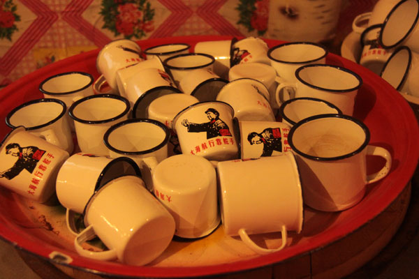 This photo on December 20, 2012, shows old-fashioned iron cups in a house made of snow, which contains a collection of local rural furniture, daily articles and hunting products in Harbin, northeast China's Heilongjiang Province. (CRIENGLISH.com)