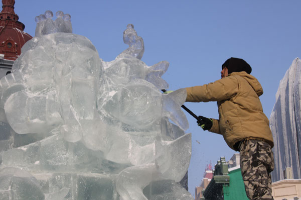 An ice sculptor carves a block of ice on Central Street in Harbin, northeast China's Heilongjiang Province, on December 18, 2012. (CRIENGLISH.com)