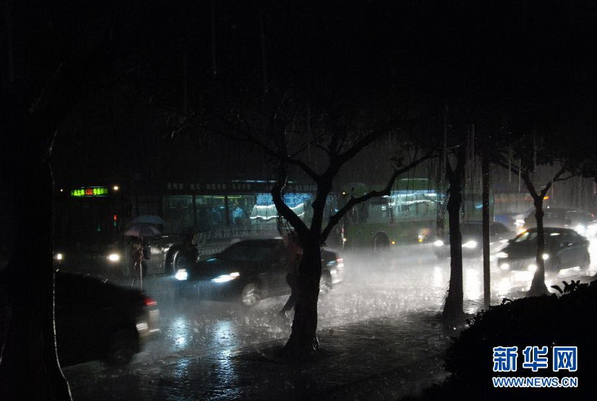 People walk in rain on a street in Guangzhou on April 20. The sky was as dark as midnight in the early morning. According to weather report, heavy rain would hit Guangzhou, Fujian, and a blue rainstorm alert was released timely on April 20. (Xinhua/ Yuan Hongwei)