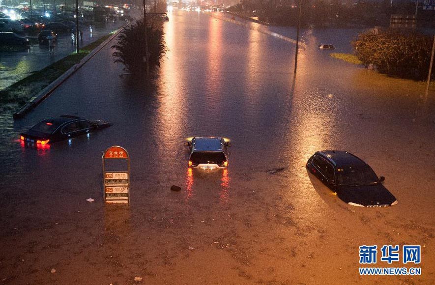 The flooding water interrupts the traffic in Lishuiqiao, Beijing, leaving many vehicles submerged in water on July 21, 2012. Beijing Meteorological Observatory issued the first orange rainstorm alert warning since the weather alert system was set up in 2005, and forecasted the rainfall would over 20 hours. (Xinhua/Zhang Yu)