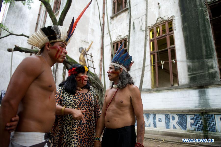Indigenous people discuss the governmental proposal outside the old Indian Museum in Rio de Janeiro, Brazil, Jan. 16, 2013. The government of Rio de Janeiro plans to tear down an old Indian museum beside Maracana Stadium to build parking lot and shopping center here for the upcoming Brazil 2014 FIFA World Cup. The plan met with protest from the indigenous groups. Now Indians from 17 tribes around Brazil settle down in the old building, appealing for the protection of the century-old museum, the oldest Indian museum in Latin America. They hope the government could help renovate it and make part of it a college for indigenous Indians. (Xinhua/Weng Xinyang) 