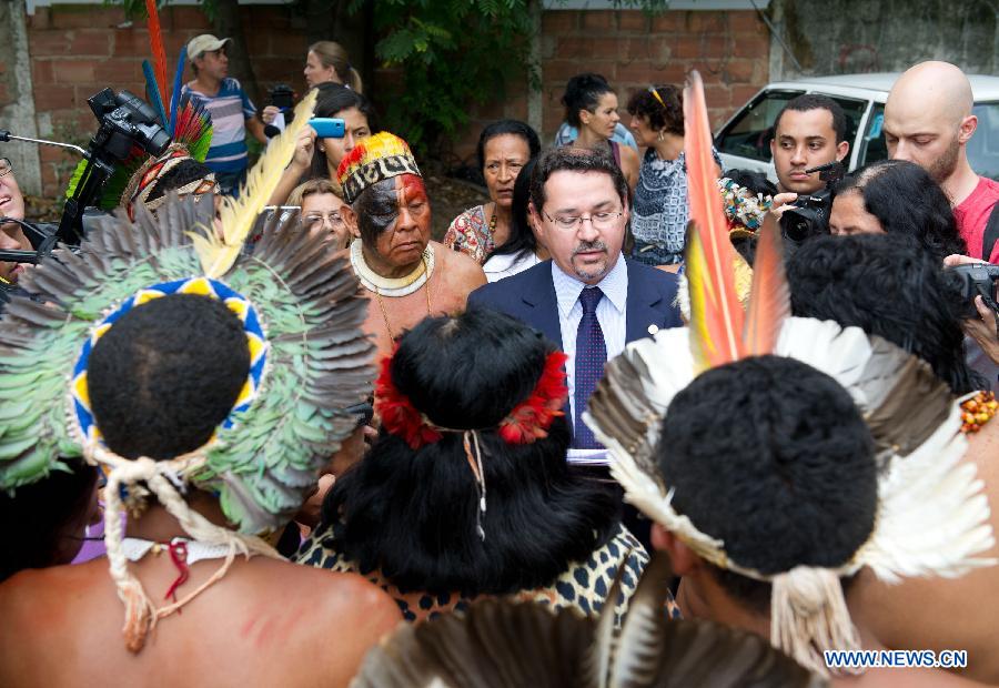 A government official reads a proposal, promising to build a new museum nearby for the Indigenous people, in Rio de Janeiro, Brazil, Jan. 16, 2013. The government of Rio de Janeiro plans to tear down an old Indian museum beside Maracana Stadium to build parking lot and shopping center here for the upcoming Brazil 2014 FIFA World Cup. The plan met with protest from the indigenous groups. Now Indians from 17 tribes around Brazil settle down in the old building, appealing for the protection of the century-old museum, the oldest Indian museum in Latin America. They hope the government could help renovate it and make part of it a college for indigenous Indians. (Xinhua/Weng Xinyang) 