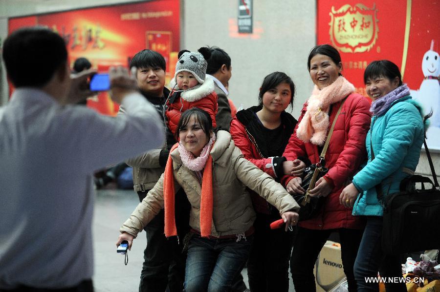 Migrant workers from east China's Jiangxi Province pose for photos at the Hangzhou Railway Station in Hangzhou, east China's Zhejiang Province, Jan. 17, 2013. Some migrant workers have started to return home in order to avoid the Spring Festival travel peak that begins on Jan. 26 and will last for about 40 days. The Spring Festival, the most important occasion for a family reunion for the Chinese people, falls on the first day of the first month of the traditional Chinese lunar calendar, or Feb. 10 this year. (Xinhua/Ju Huanzong) 