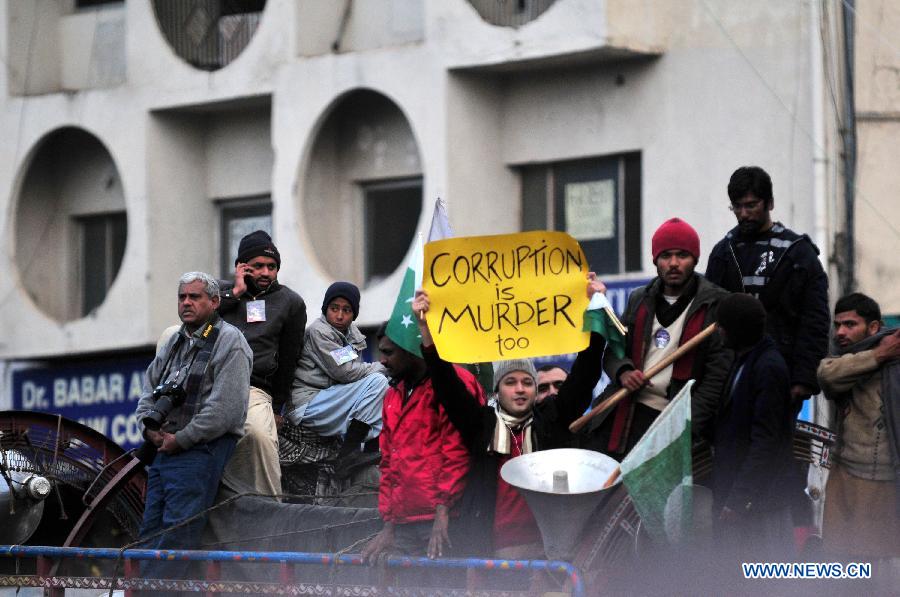 A supporter of Pakistani religious leader Tahir-ul-Qadri holds a placard on the fourth day of a long-march protest rally in Islamabad, capital of Pakistan, Jan. 17, 2013. Pakistani ministers held talks with Tahir-ul-Qadri on Thursday in an attempt to avert a political crisis and end a demonstration that has heaped pressure on the fragile government. (Xinhua/Ahmad Kamal) 