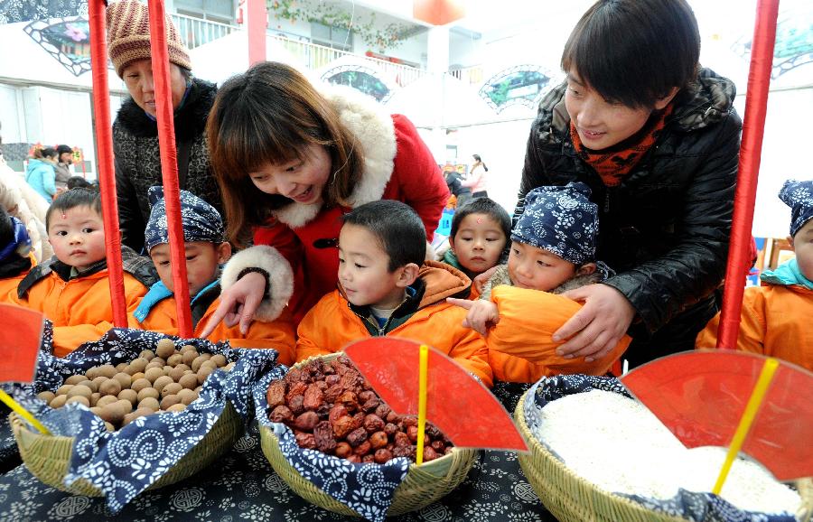 Children learn to recognize the food materials of Laba porridge in the senic spot of Huqiu Mountain in Suzhou, east China's Jiangsu Province, Jan. 17, 2013. Kindergarten Children together with their parents and teachers attended an activity to welcome the coming Laba Festival which falls on Jan. 19 this year. Laba festival, literally the eighth day of the twelfth lunar month, is considered the prelude of Chinese Spring Festival. (Xinhua/Hang Xingwei) 
