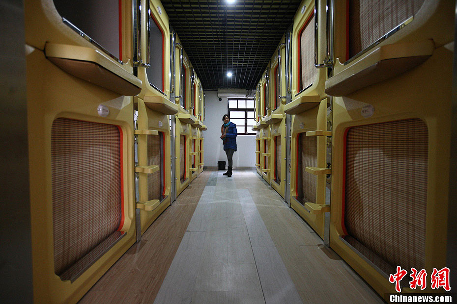A reporter experiences the "capsule hotel" on the Tianjin Road in Qingdao, a city in east China's Shandong province. (CNSPHOTO/ Xu Congde)