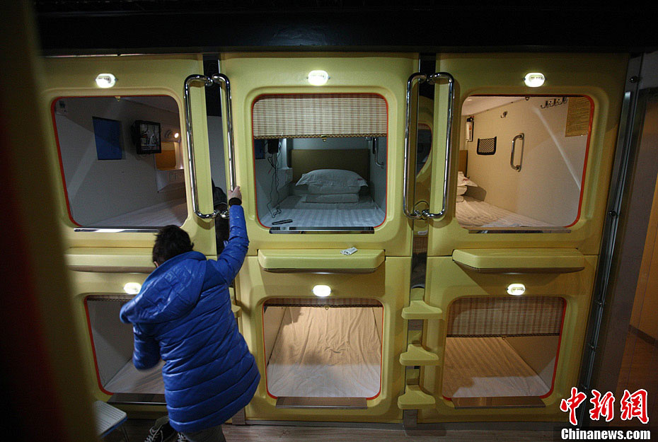 A reporter experiences the "capsule hotel" on the Tianjin Road in Qingdao, a city in east China's Shandong province. (CNSPHOTO/ Xu Congde)
