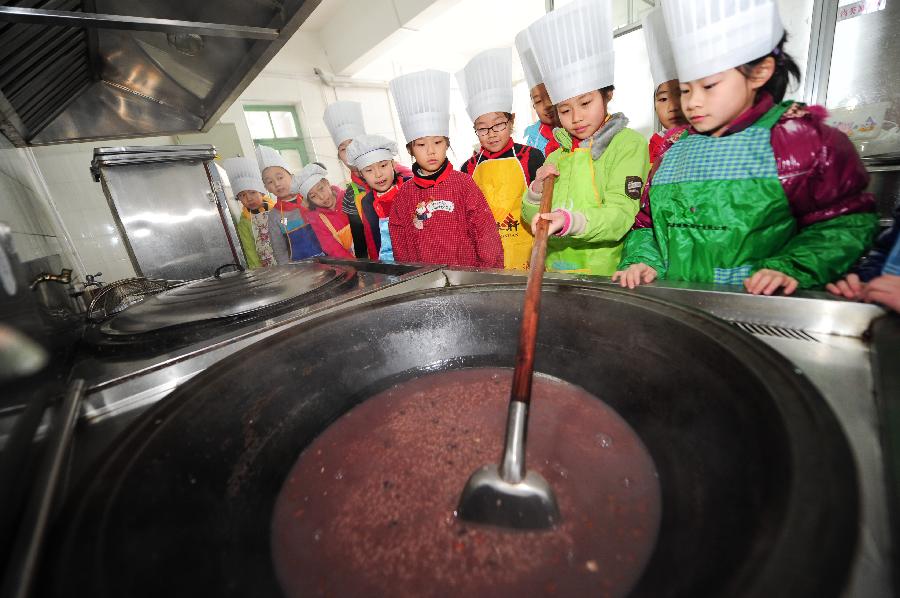 Students learn to cook Laba porridge in Yantai, east China's Shandong Province, Jan. 17, 2013. Students from a primary school attended an activity to welcome the coming Laba Festival which falls on Jan. 19 this year. Laba festival, literally the eighth day of the twelfth lunar month, is considered the prelude of Chinese Spring Festival. (Xinhua/Chu Yang) 