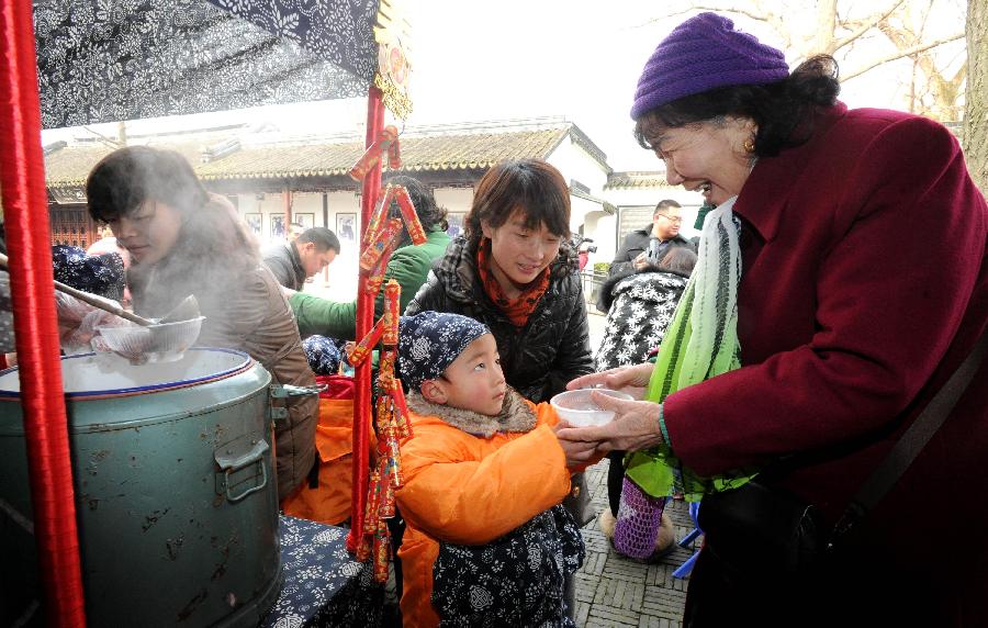 A boy gives Laba porridge to a visitor in the senic spot of Huqiu Mountain in Suzhou, east China's Jiangsu Province, Jan. 17, 2013. Kindergarten Children together with their parents and teachers attended an activity to welcome the coming Laba Festival which falls on Jan. 19 this year. Laba festival, literally the eighth day of the twelfth lunar month, is considered the prelude of Chinese Spring Festival. (Xinhua/Hang Xingwei) 