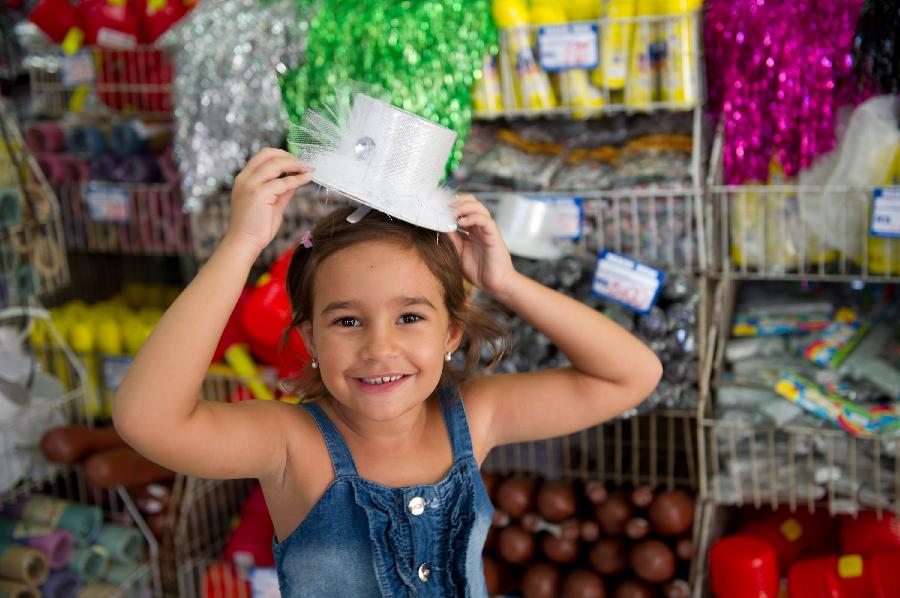 A girl tries on a carnival hat in a store in central Rio de Janeiro, Brazil, Jan. 18, 2013. Carnival-related products sell like hot cakes in Brazil, three weeks away from the annual Rio de Janeiro Carnival. (Xinhua/Weng Xinyang) 