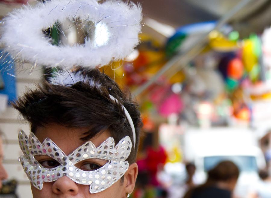 A man wears a carnival mask outside a store in central Rio de Janeiro, Brazil, Jan. 18, 2013. Carnival-related products sell like hot cakes in Brazil, three weeks away from the annual Rio de Janeiro Carnival. (Xinhua/Weng Xinyang) 