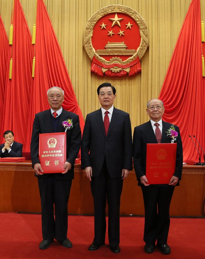 Chinese President Hu Jintao (C) awards certificates to explosions expert Zheng Zhemin (R) and radar engineer Wang Xiaomo in the awarding ceremony of the State Scientific and Technological Award in Beijing, capital of China, Jan. 18, 2013. Zheng and Wang won China's top science award on Friday. (Xinhua/Ju Peng) 