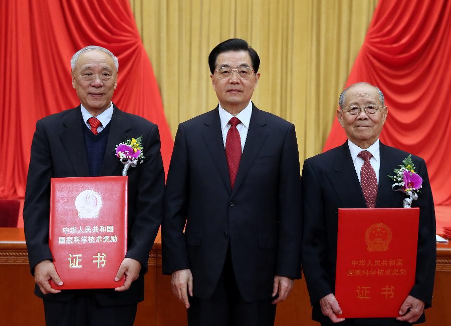 Chinese President Hu Jintao (C) awards certificates to explosions expert Zheng Zhemin (R) and radar engineer Wang Xiaomo in the awarding ceremony of the State Scientific and Technological Award in Beijing, capital of China, Jan. 18, 2013. Zheng and Wang won China's top science award on Friday. (Xinhua/Ju Peng) 