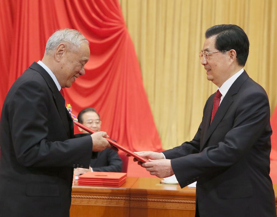 Chinese President Hu Jintao (R) presents the certificate to radar engineer Wang Xiaomo in the awarding ceremony of the State Scientific and Technological Award in Beijing, capital of China, Jan. 18, 2013. Wang, 74, who is member of Chinese Academy of Engineering (CAE), won China's top science award on Friday. (Xinhua/Ju Peng) 