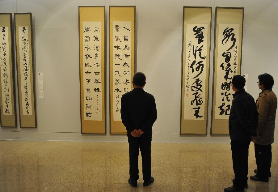 People view couplet calligraphy works at the "Calligraphy Inheriting--New Year Couplet Calligraphy Exhibition" at the National Art Museum of China in Beijing, capital of China, Jan. 18, 2013. The exhibition kicked off on Friday, displaying over a hundred couplet works.(Xinhua/Lu Peng) 