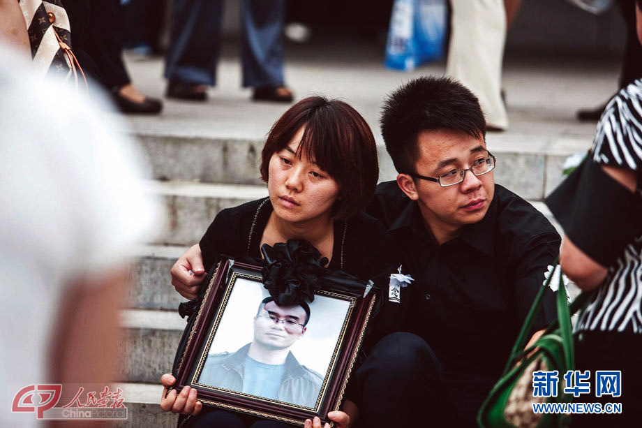 At a memorial service held for Ding Zhijian, a victim of the torrential rain in downtown Beijing on July 25, 2012, his wife looks desperate. (Photo/China Pictorial)  