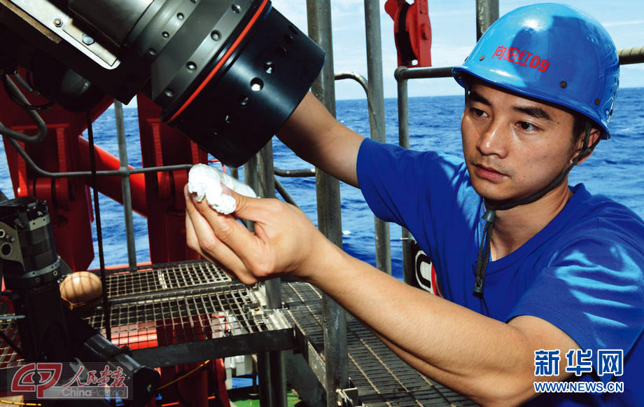Fu Wentao checks the lighting equipment of Jiaolong submersible before diving on June 29, 2012. (Photo/China Pictorial)