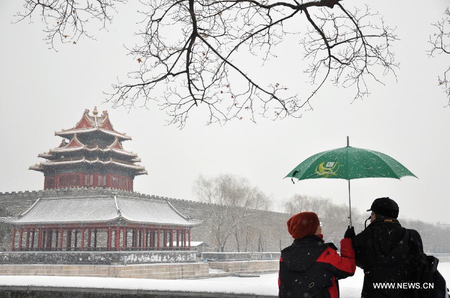 Visitors take photos of a snow-covered watchtower of the Palace Museum, also known as the Forbidden City, in Beijing, capital of China, Jan. 20, 2013. A snow hit the capital city on Sunday. (Xinhua/Wang Junfeng)  