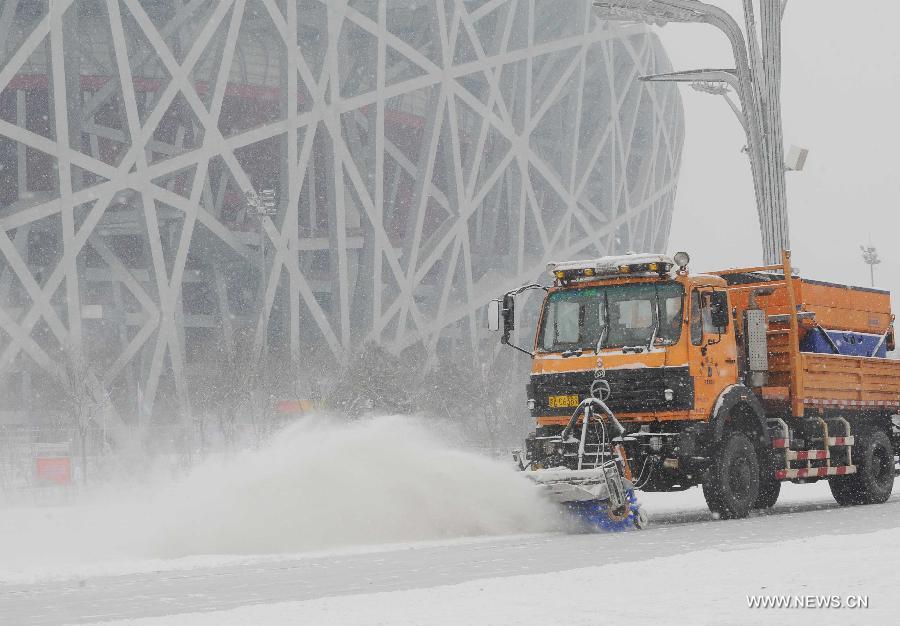 A vehicle works to clear snow at the Beijing Olympic Park in Beijing, capital of China, Jan. 20, 2013. A snow hit the capital city on Sunday. (Xinhua/Gong Lei) 