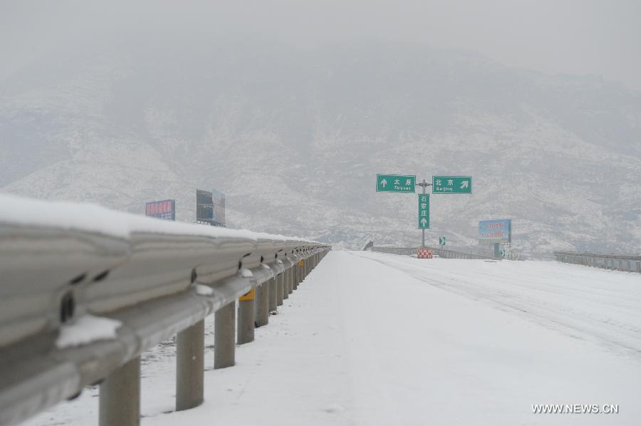 The closed Beijing-Kunming Expressway is covered with snow in Tangxian County, north China's Hebei Province, Jan. 20, 2013. Snow fell in most parts of Hebei Province on Jan. 19 evening and 19 expressways in the province have been closed. (Xinhua/Zhu Xudong) 