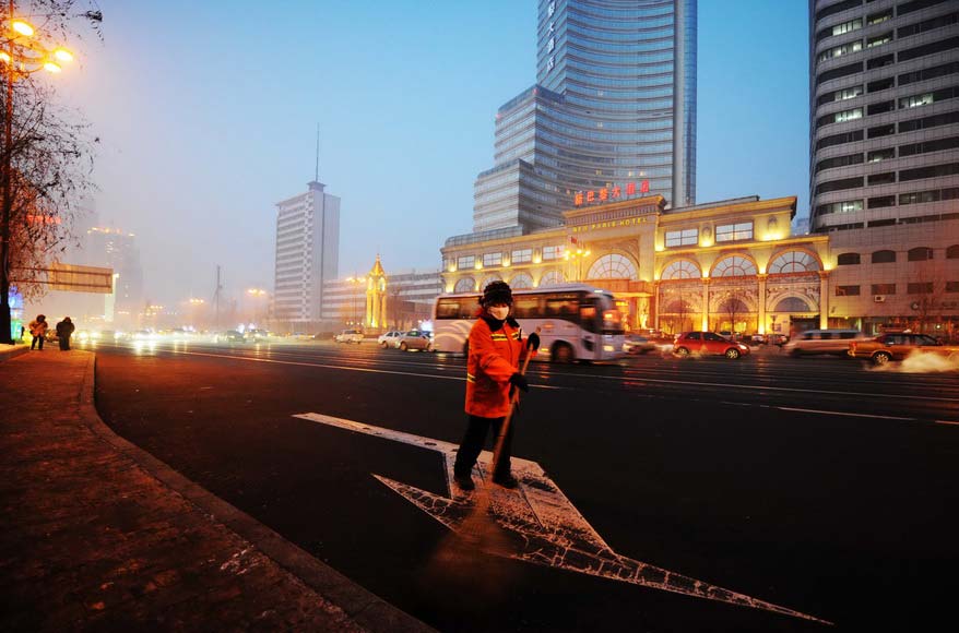 Yanng Weixia, a sanitation worker, cleans the street late at night on Jan. 16, 2013. (Xinhua/Wang Jianwei)